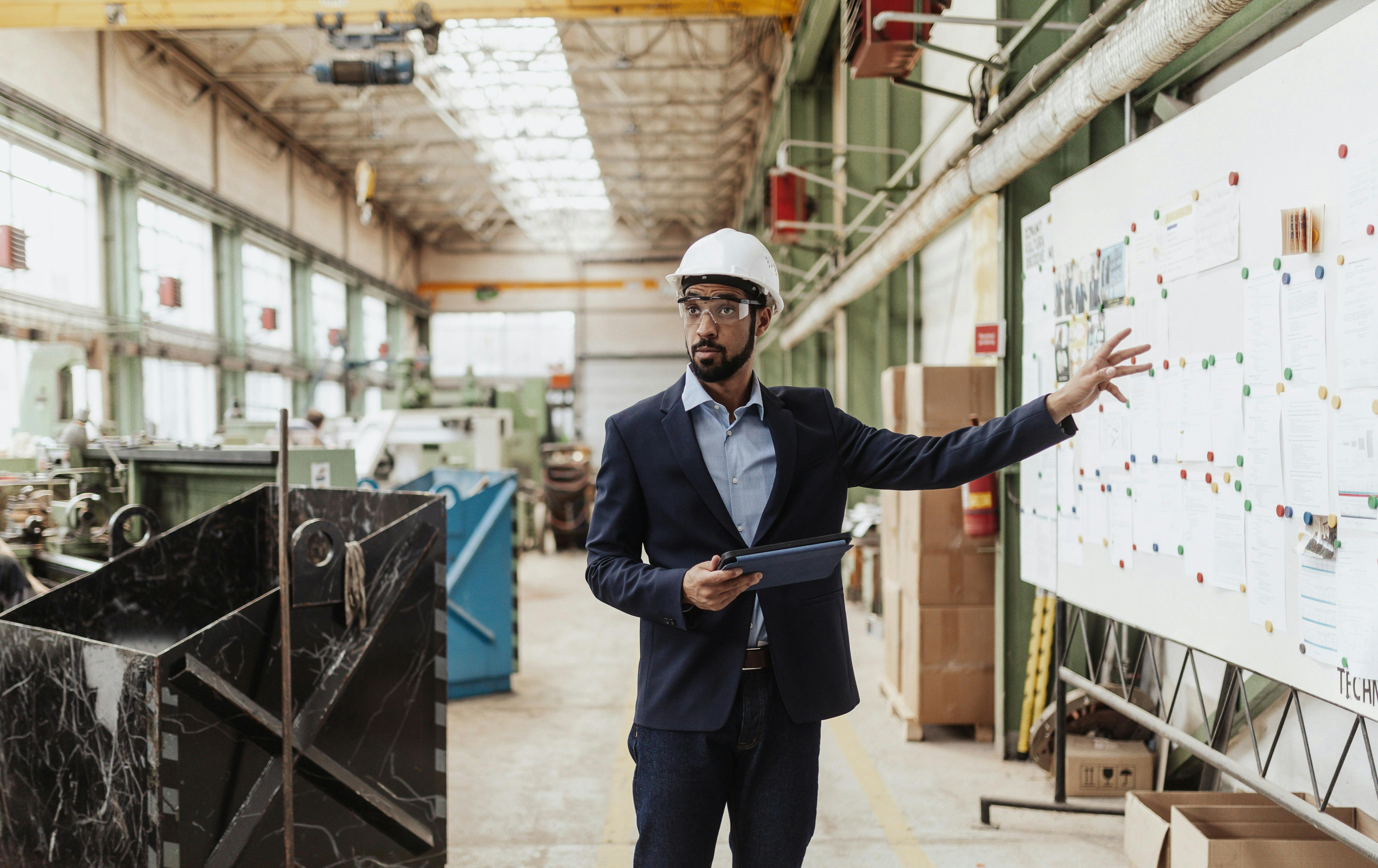 A reliability engineer pointing at a table of production planning