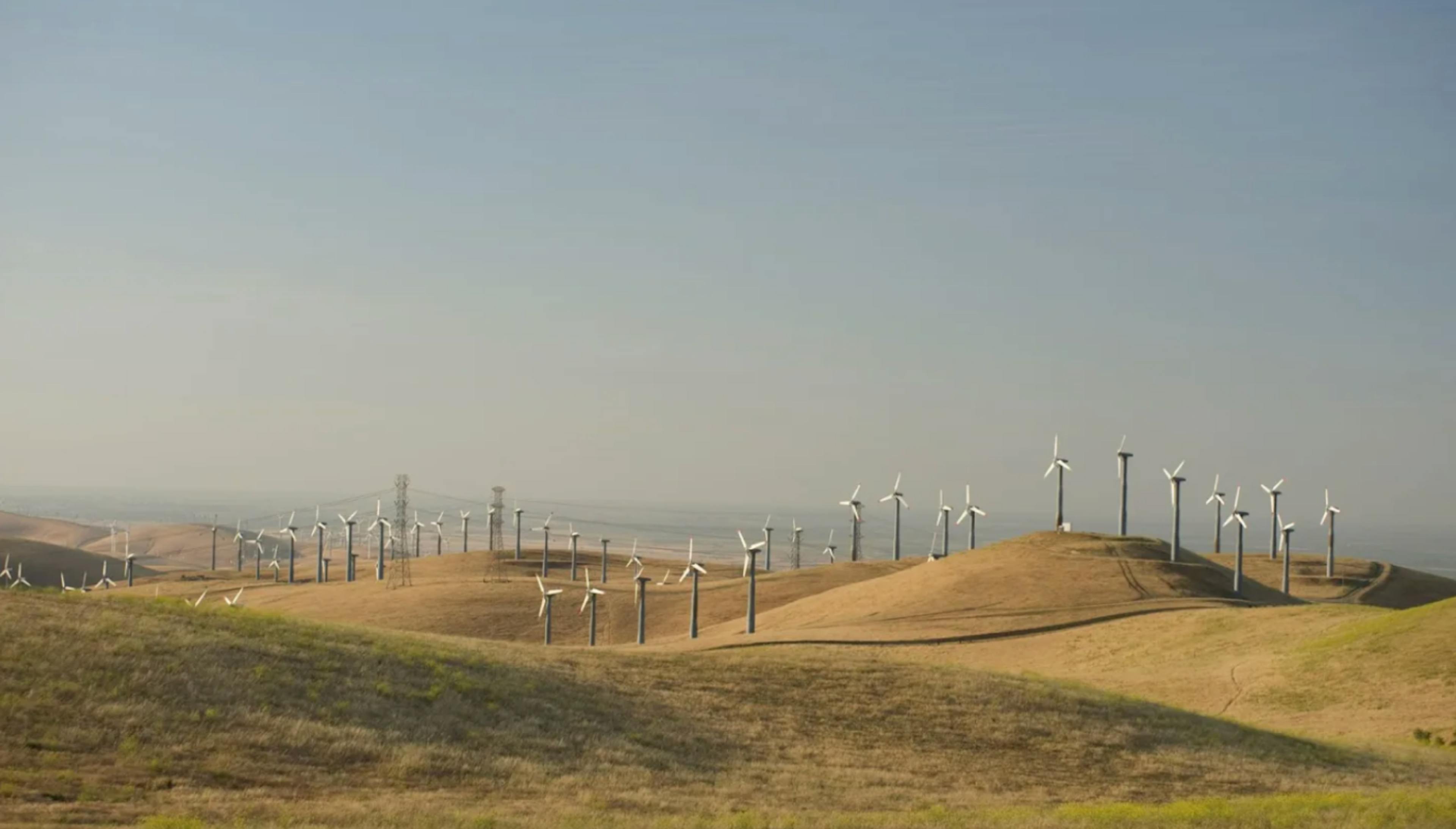 Landscape photograph of wind turbines on a rolling grassy plain