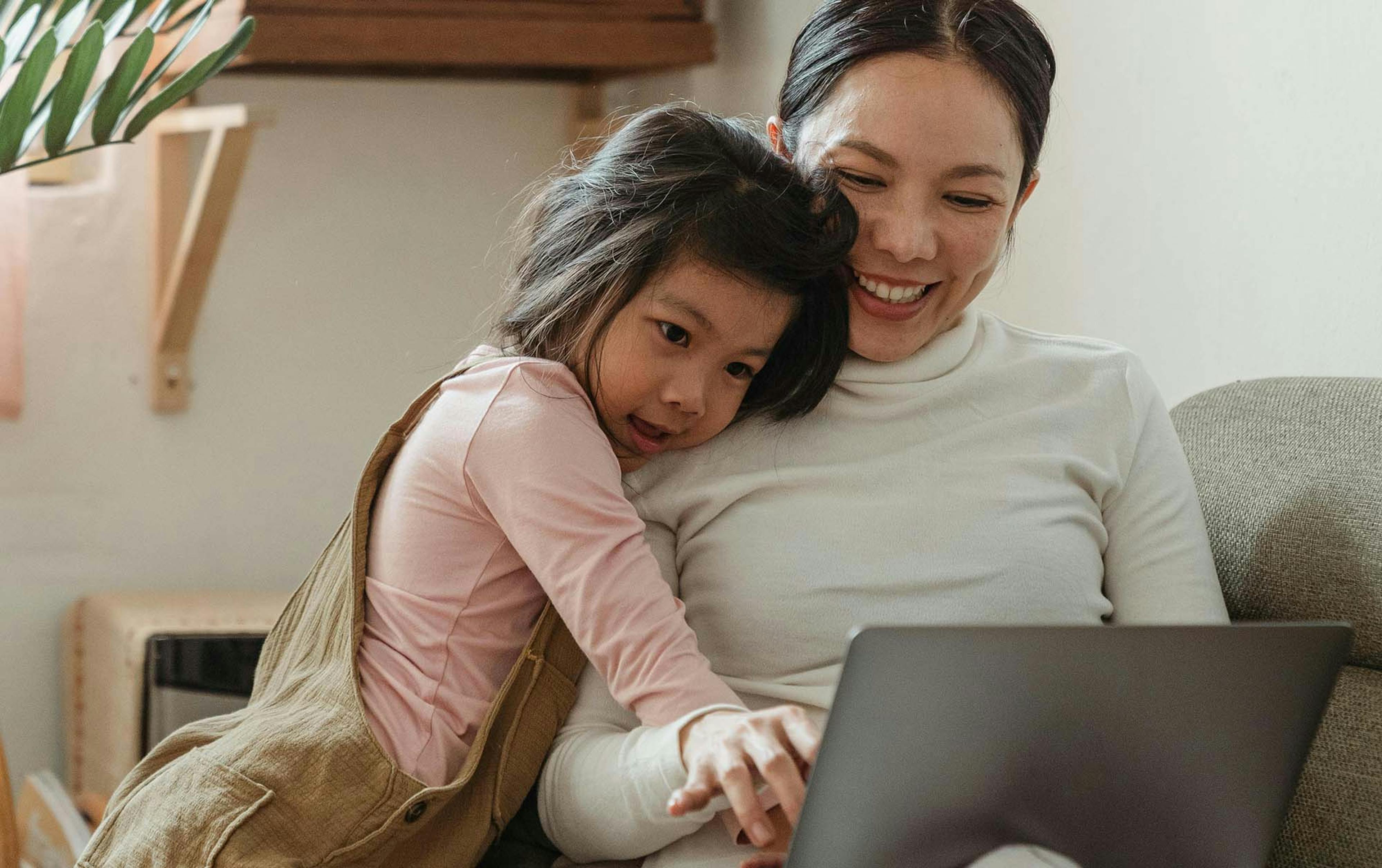 Photograph of a mother and daughter looking at a laptop