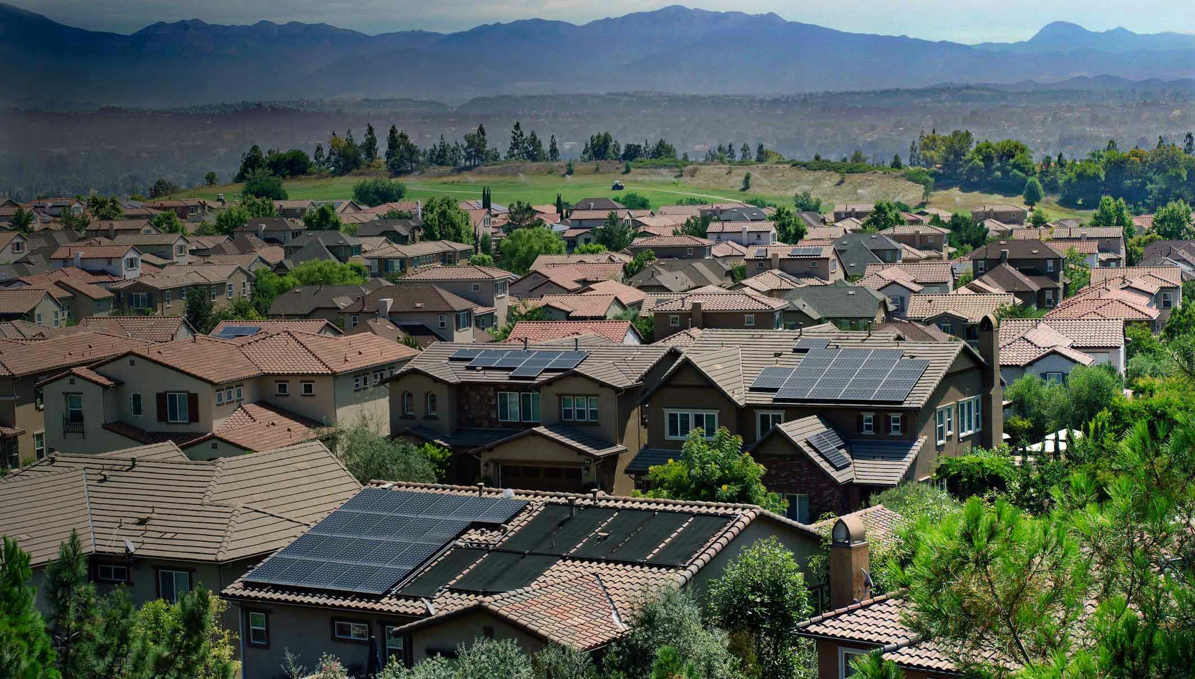 Photograph overlooking homes with solar panels on their roofs