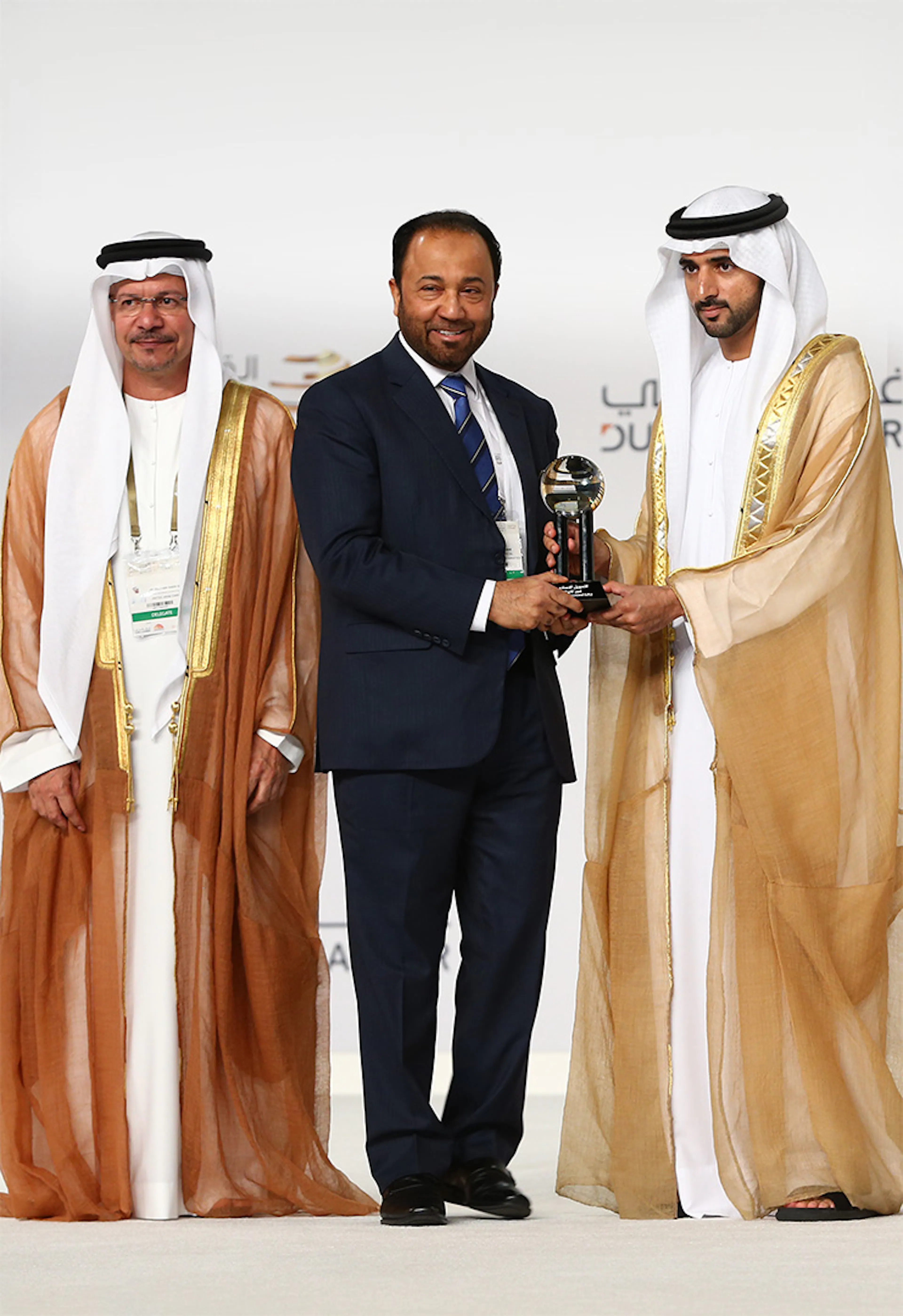 Fajr Capital executive receiving an award alongside Emirati dignitaries in traditional dress