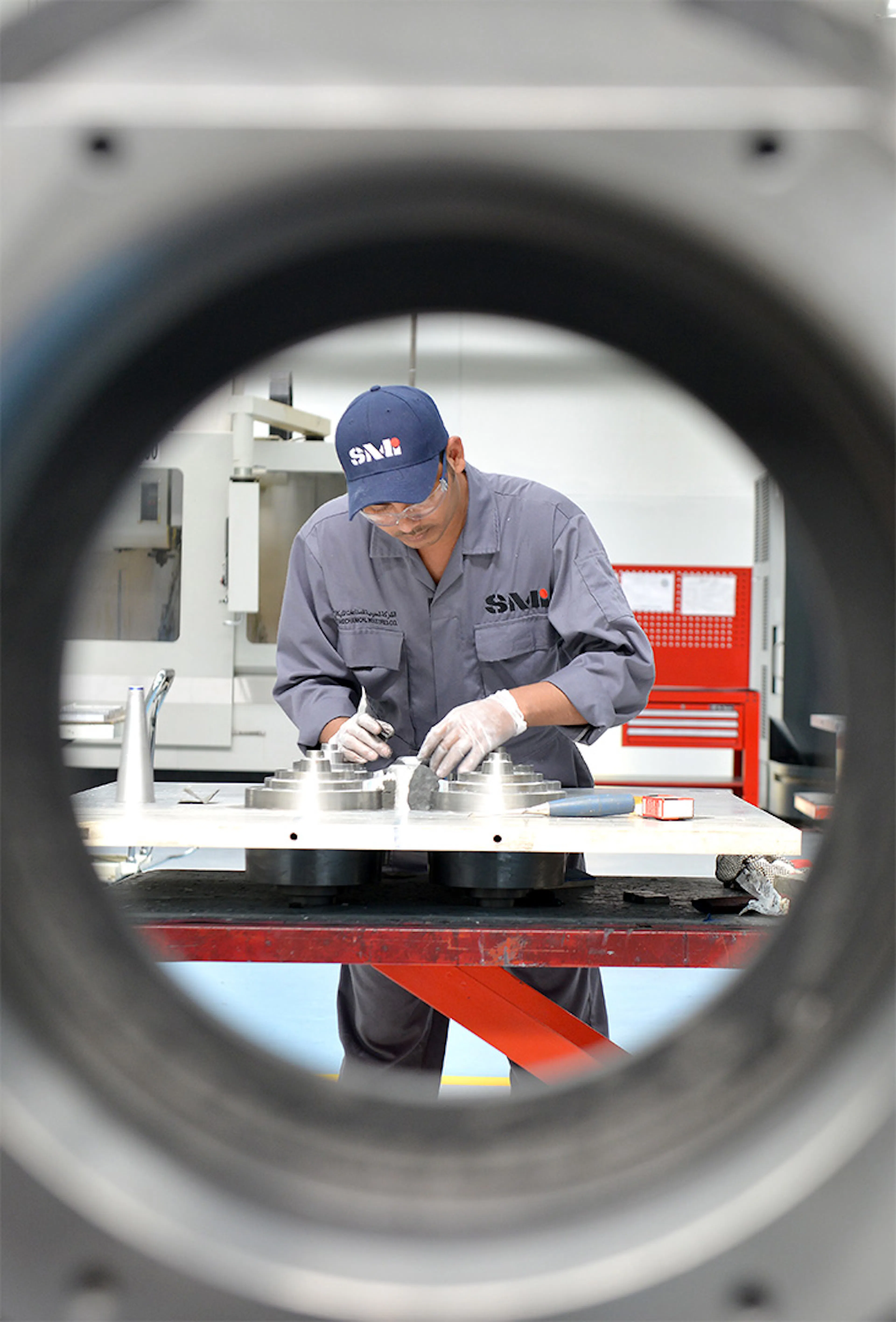 Technician inspecting precision-machined metal components at a manufacturing facility
