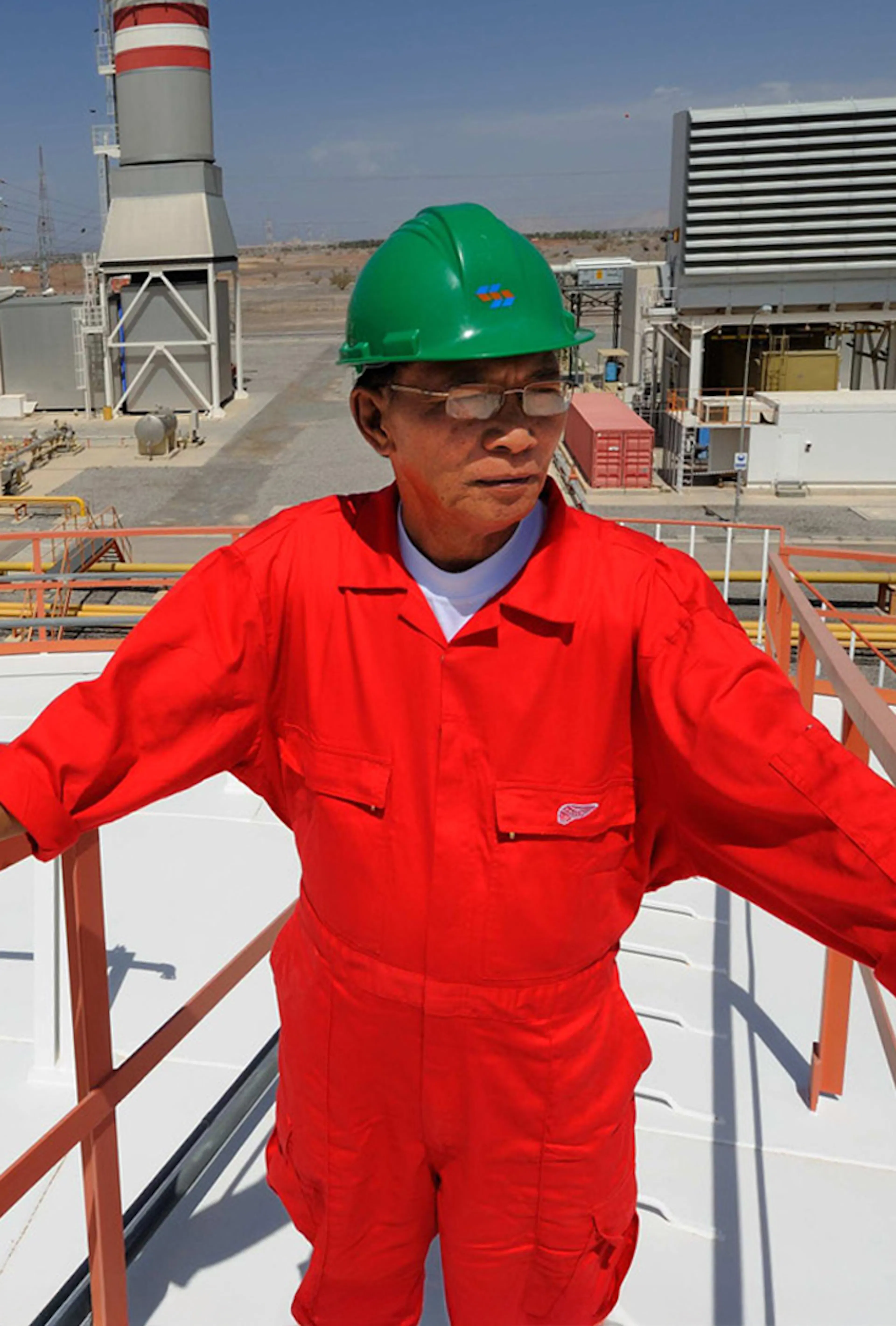Worker in safety gear at an industrial power plant site