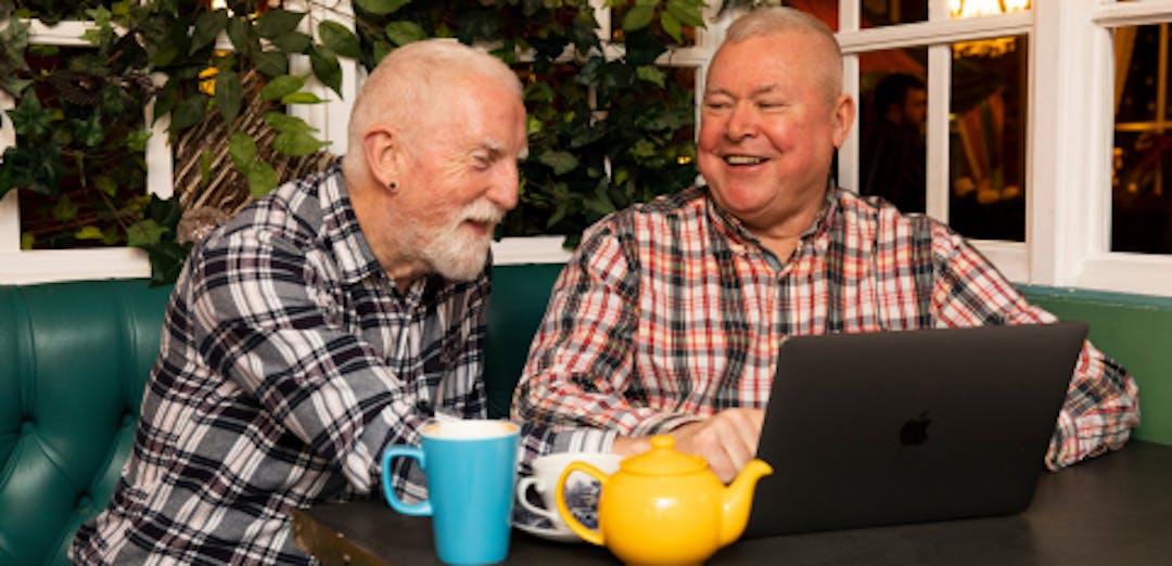Old men using a laptop and laughing