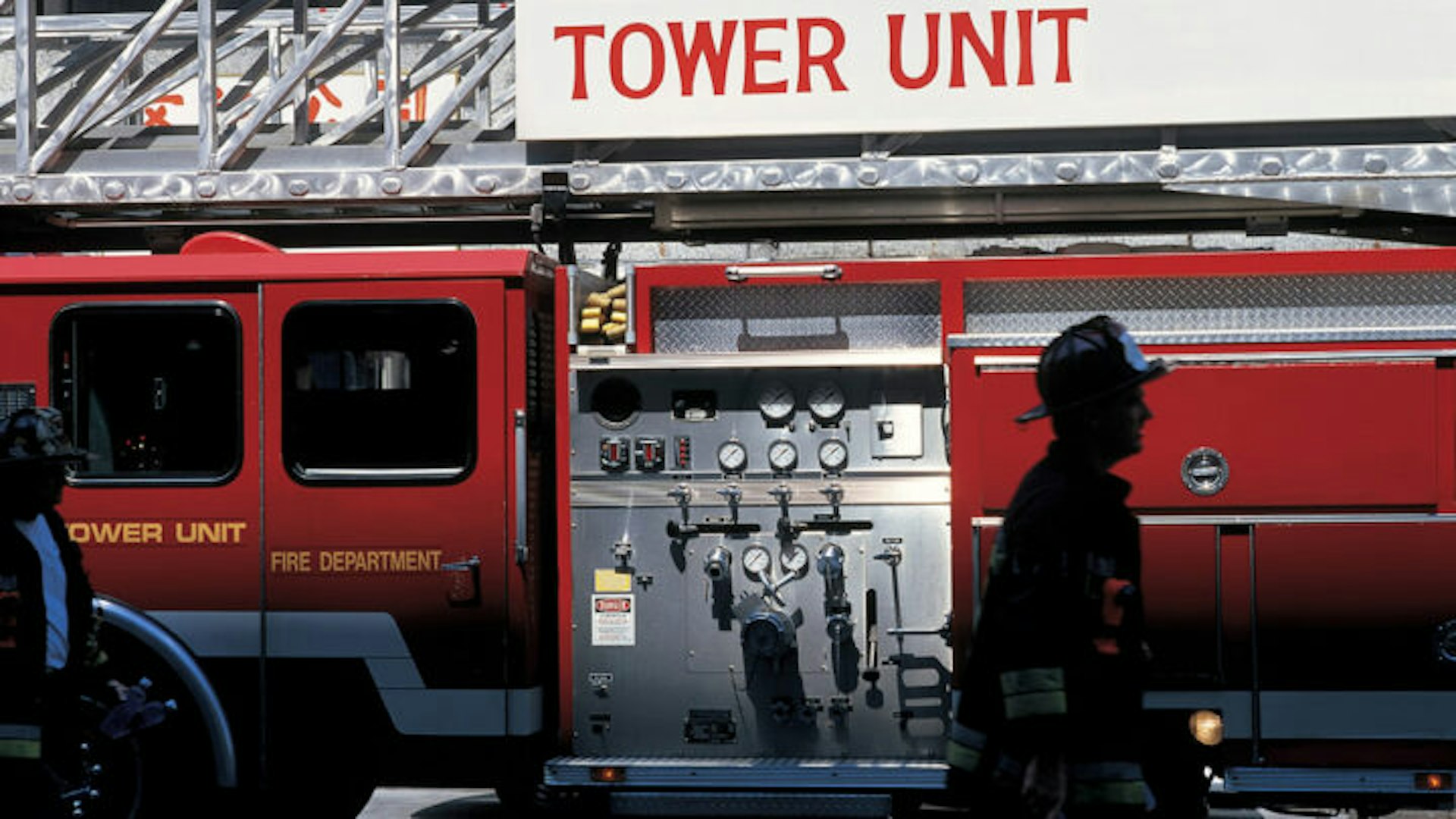 Image of a fire fighter walking in front of a fire truck.