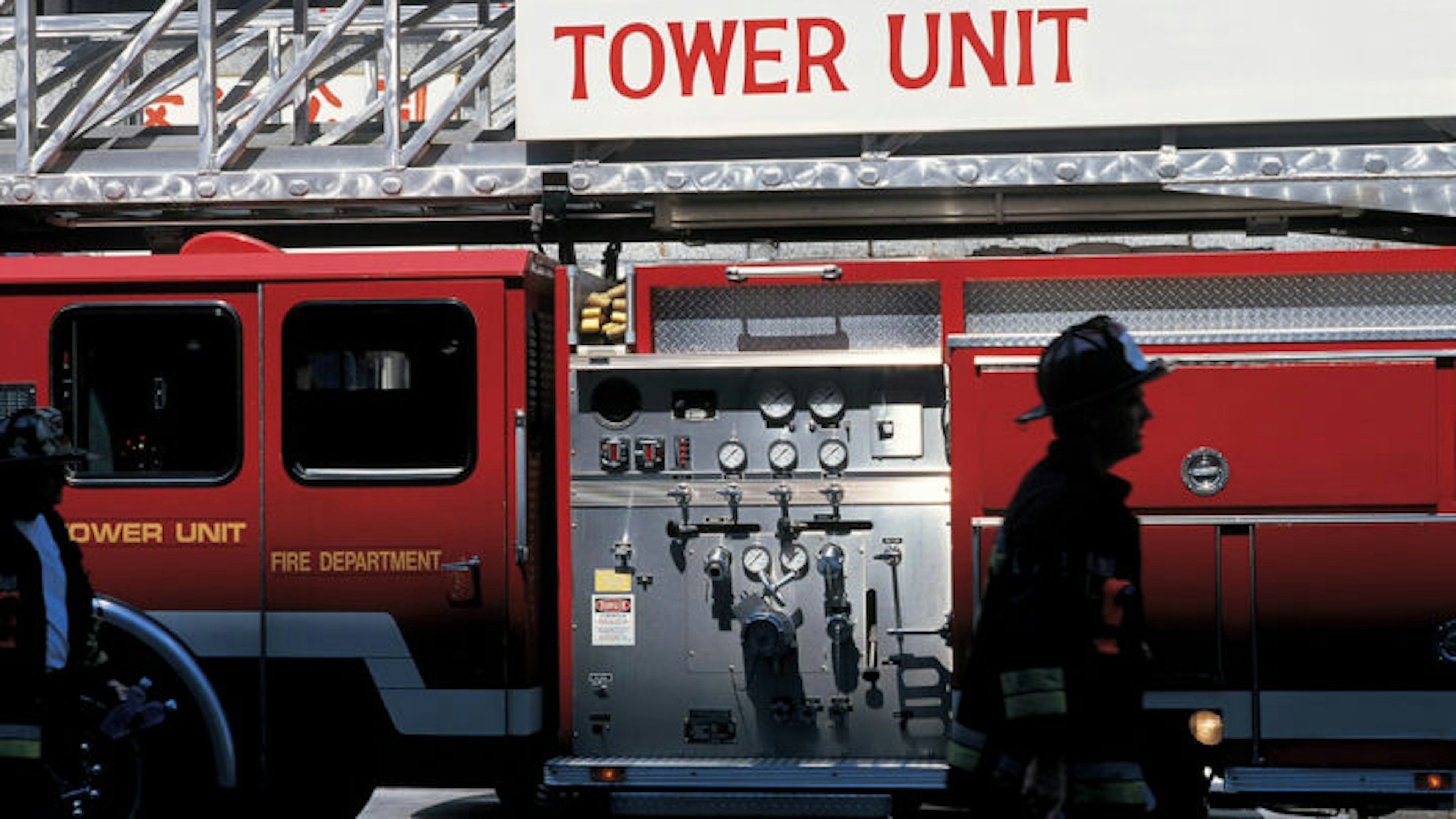 Image of a fire fighter walking in front of a fire truck.