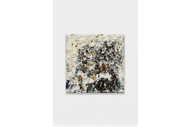 Abstract painting of a brown, black and ochre colored tree on white paint. 