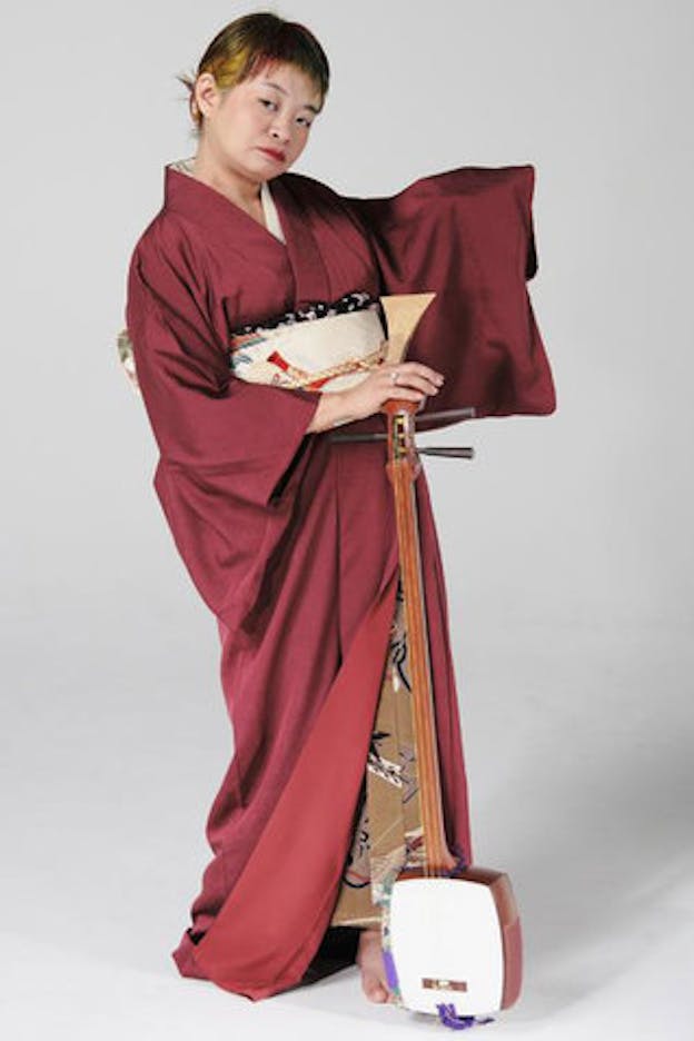 Nexus6 performs in a red kimono with a shamisen by her feet. 
