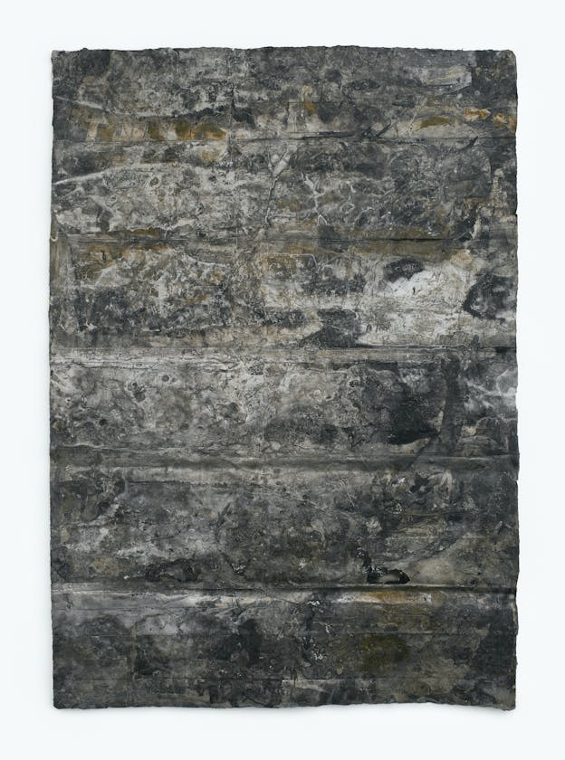 A single sheet of paper with deep fold lines and crumpled ridges painted with mottled white, tan, gray, and black.