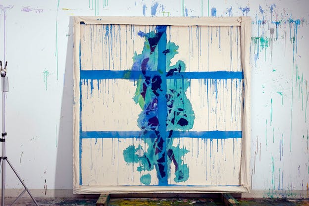 Installation view of a cream white canvas divided by 3 x 2 rows of cobalt blue lines dripping blue paint that resemble the cyan, turquoise, and perriwinkle dripping paint on the wall hosting the work. In the center of the canvas is an accumulation of blotted indigo, turquoise, and cyan blue. 