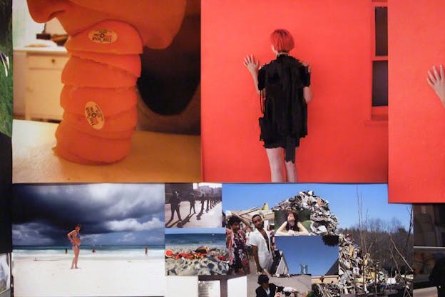 A collage of images showing a mouth engulfing a tower of mandarin peels, a figure dressed in black facing a red wall, a figure in a swimsuit  on a beach surrounded by gray clouds and multiple other small pictures. 