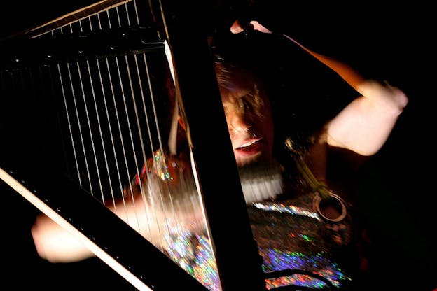 A blurred close up image of a person playing a musical instrument.
