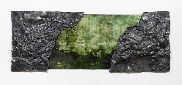 A long rectangular painting with textured sheets of dark grey geological material affixed on the sides, covering a portion of the face of the painting. The painted portion visible in the middle between the two sheets is painted in mottled shades of green that bleed into one another. 