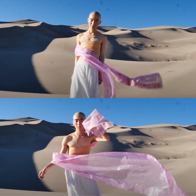 Two stacked film stills of eddy kwon standing with her eyes closed in front of sand dunes and a clear blue sky. She wears a white skirt, an orange bandeau top, and is draped in a pink scarf that is blowing in the wind. In the top still her arms are by her side and she is leaning slightly to her left. In the bottom still she stands straight, her left hand lifted by her head and her right hand held slightly out from her hip.