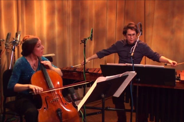 Two performers, one dressed in a blue shirt and the other in a gray button up, playing the double bass and xylophone.