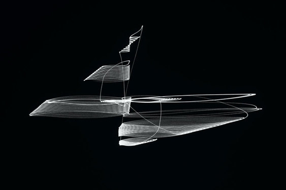 Glowing white lines spool and spiral, creating an abstract shape against a pitch black background.