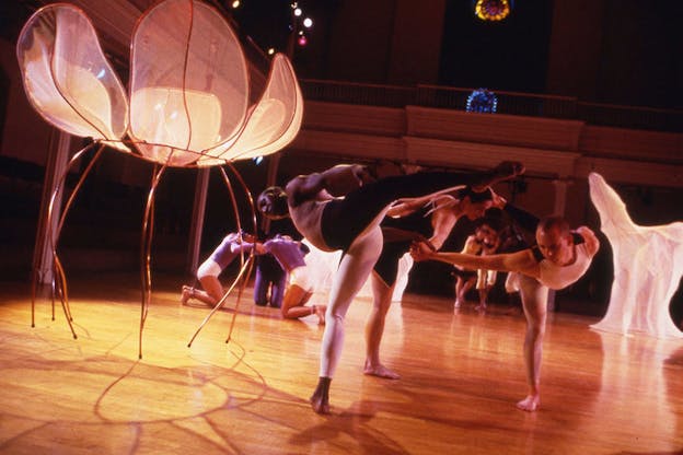 Performers on stage pirouette with one leg mid air.