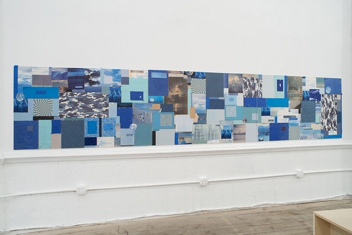 A panoramic collage of images with blue hues and undertones, on a wall.