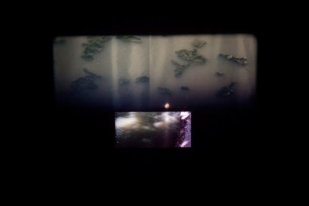 Rectangular image of what appears to be muddy water speckled with light flowing along concrete suspended in black space beneath a larger rectangle depicting a close-up of muddy water and floating green leaves.
