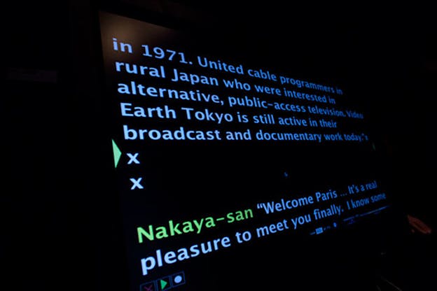 Sideways shot of a black screen projecting blue-colored text discussing an interview between 