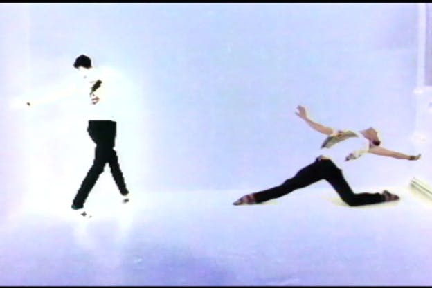 Two performers are in an overexposed bare space. They wear white t-shirts and black pants. The performer on the left spins towards their left and the performer on the right has their limbs splayed and leans backwards.  A performer wears a short blonde wig, bejeweled grey sunglasses, and a white shirt. Their face is covered by magazine cutouts. 