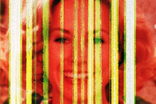 Close-up of a smiling woman's face saturated in fire-red and superimposed with semitransparent neon yellow lines. 