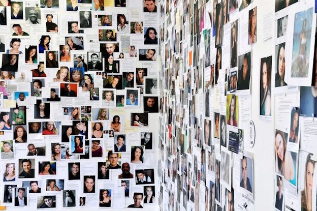A collage on a wall of various portrait photographs.