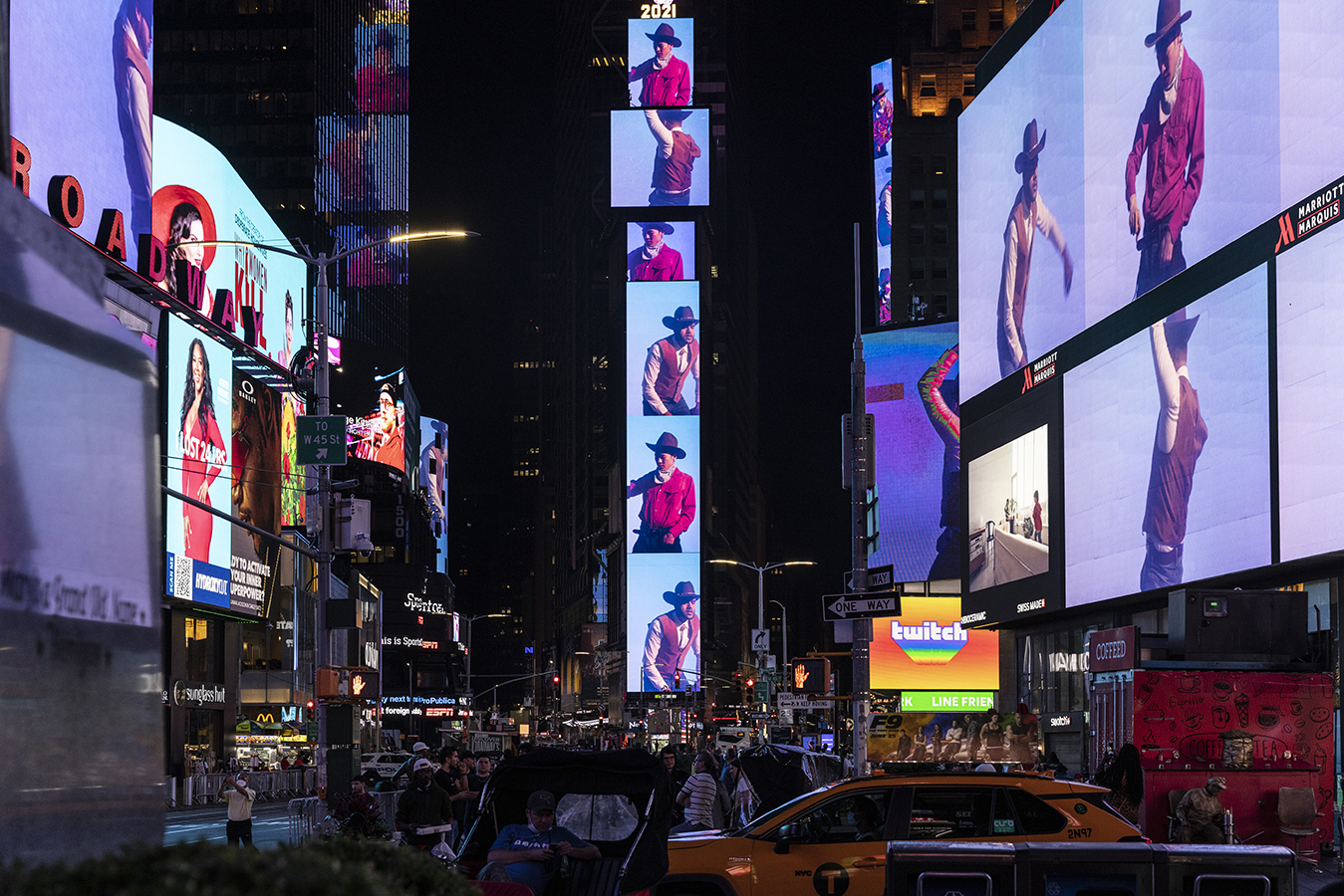 Videos of performers wearing cowboy hats, red shirts, bandanas and brown vests are projected onto large screens in Times Square.