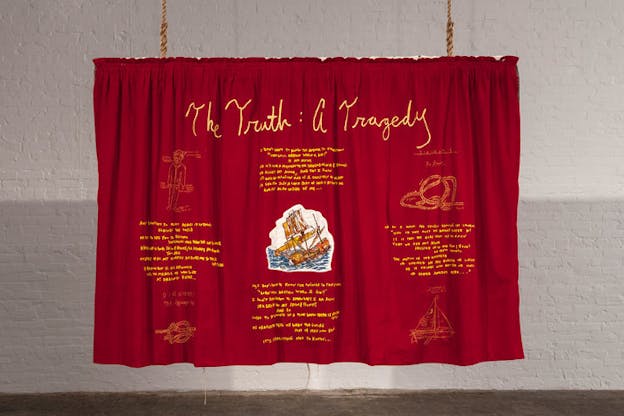 Suspended cherry-red drape with yellow embroidered words: 