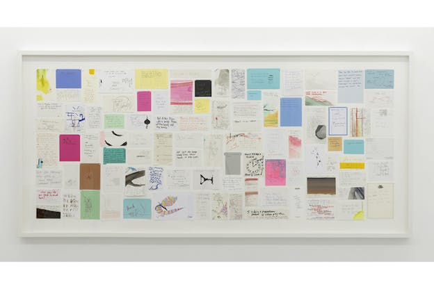 A white rectangular frame with a wall of various colored and size notes with writings and drawings on them.