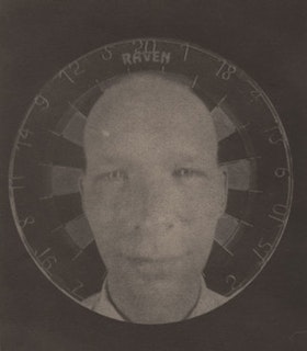 A black and white portrait of Roger Newton. Only Newton's head and neck is visible. He wears a white collared shirt and is bald. He smiles. In the background, there is a circular target against an otherwise plain background.
