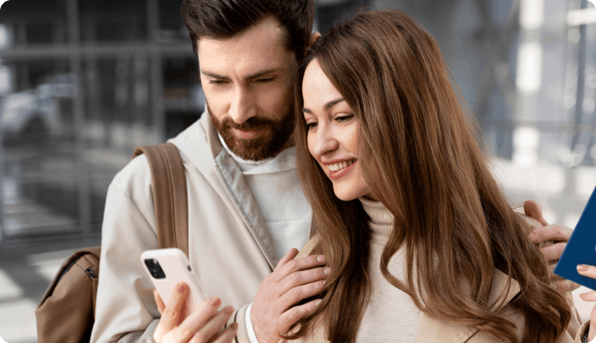Couple using a phone to signup for basis insurance in Germany