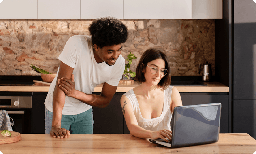 Two colleagues checking the available insurance plans that their company provided to them on a laptop.