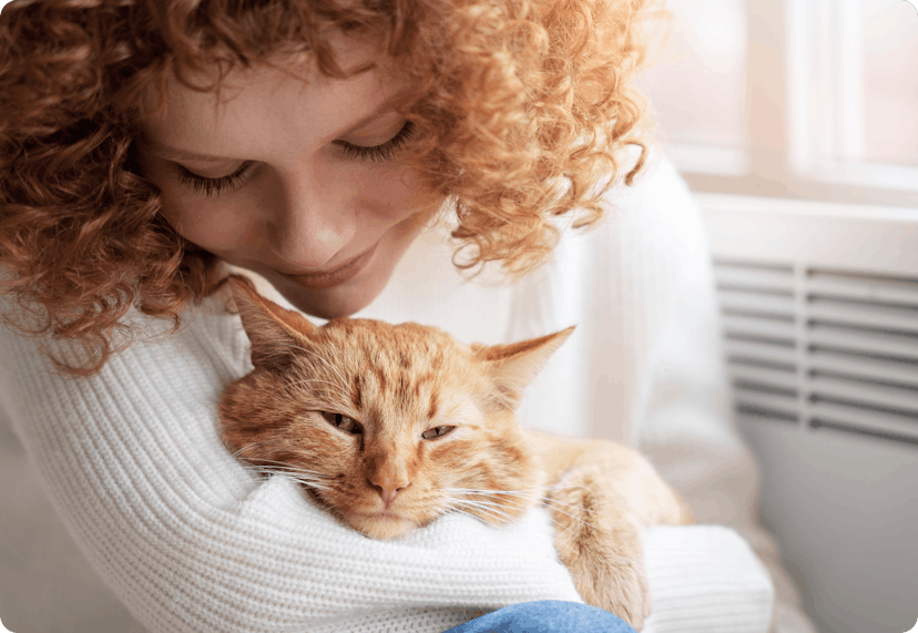 Woman holding her ginger cat