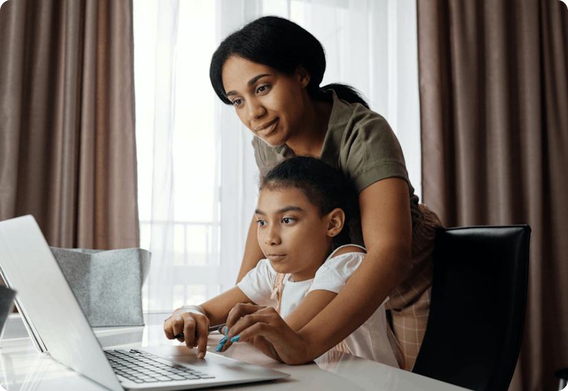 Mother and her daughter doing homework on laptop