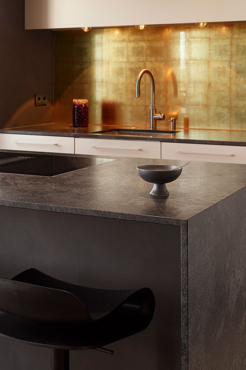 Monoblock-Küche aus Mystic-Black-Naturstein und Glas-Rückwand mit Blatt-Gold-Hinterlegung