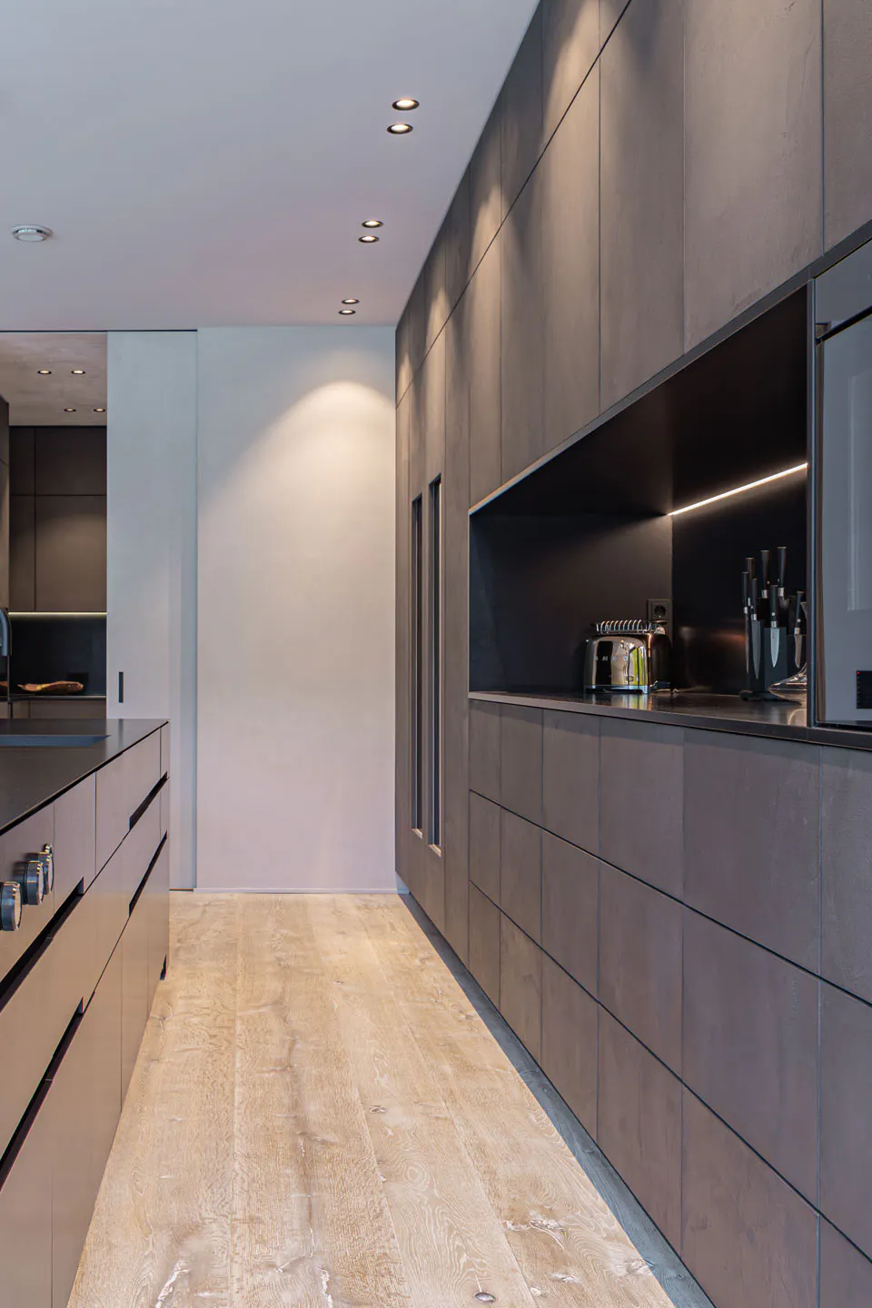 Natursteinküche bestehend aus Naturstein-Monoblock und Rückwand mit gespachtelten Betonfronten