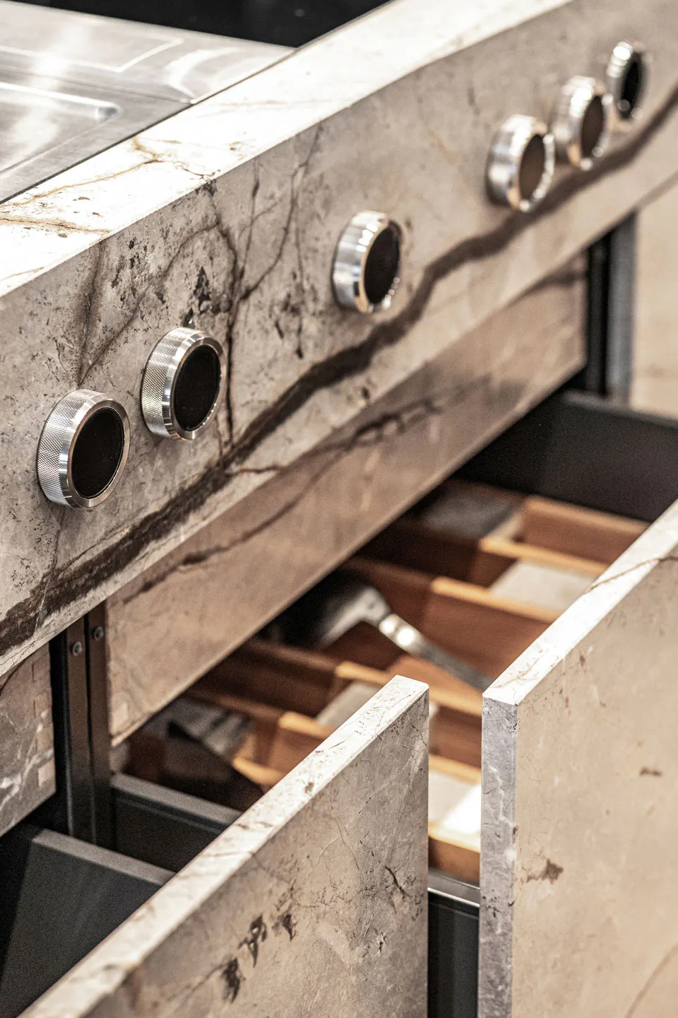 Stylische Armaturen und Auszüge einer Naturstein-Monoblock-Küche