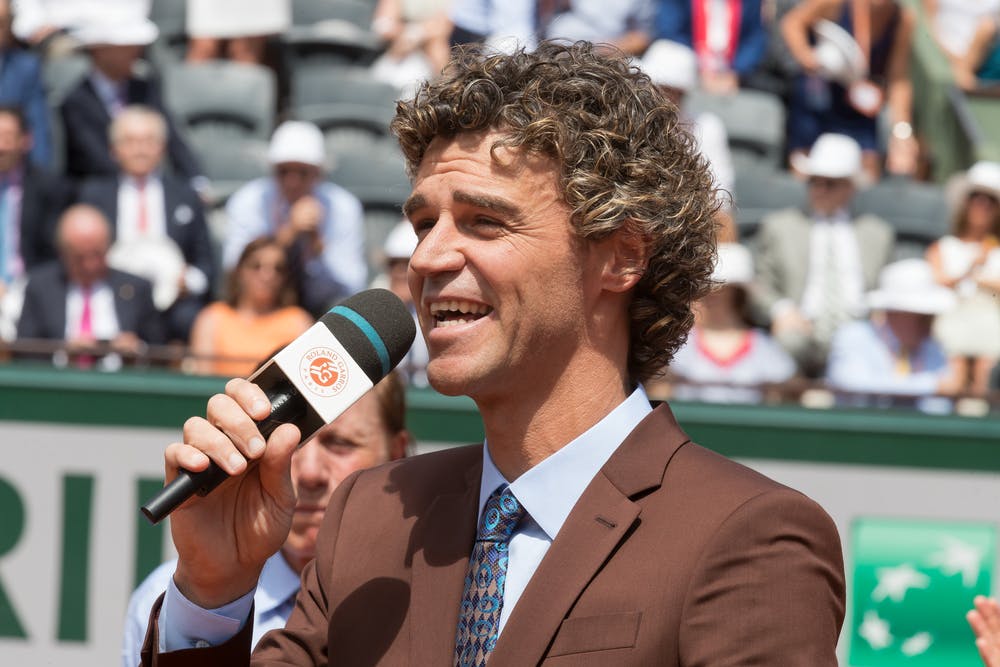 Gustavo Kuerten talking and smiling during a ceremony at Roland-Garros 2017