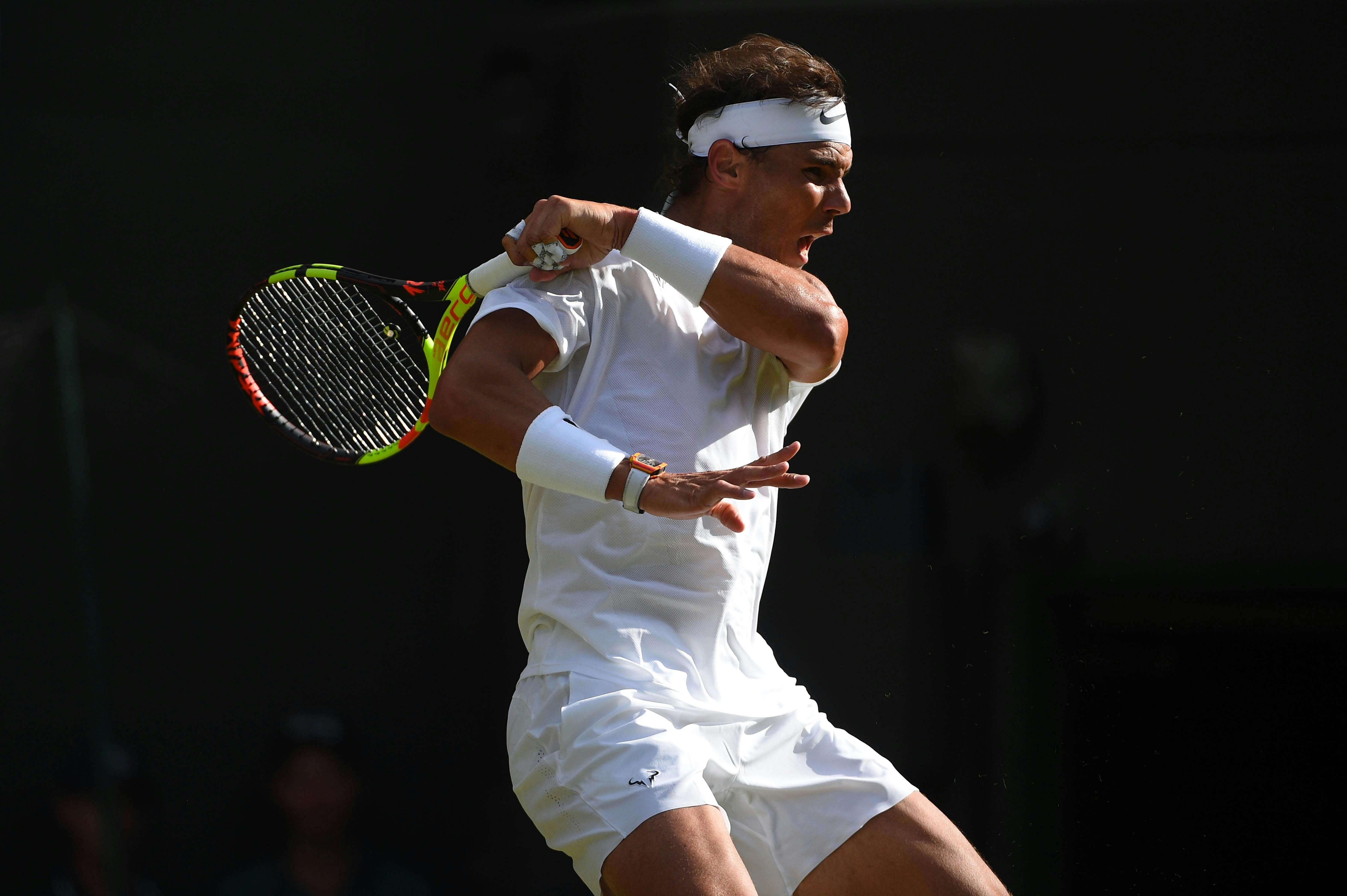 Rafael Nadal hitting a forehand in the light and shadow Wimbledon 2019