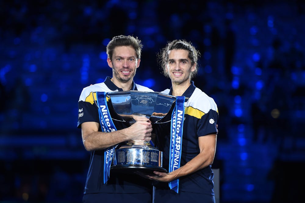 Nicolas Mahut and Pierre-Hugues Herbert holding their 2021 ATP Finals trophy