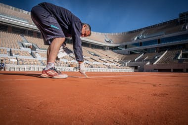 Le personnel d'entretien peint les lignes du court Philippe-Chatrier avant Roland-Garros 2019.