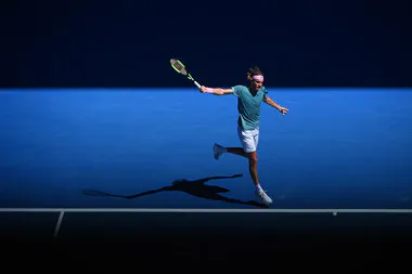 Stefanos Tsitsipas hitting a backhand in the beautiful light of the 2019 Australian Open