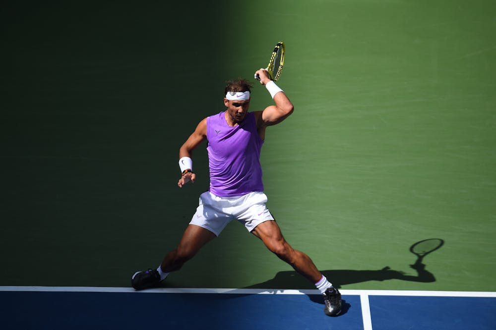 Rafael Nadal hitting a forhand in the light and shadow during hirs third round match at the 2019 US Open