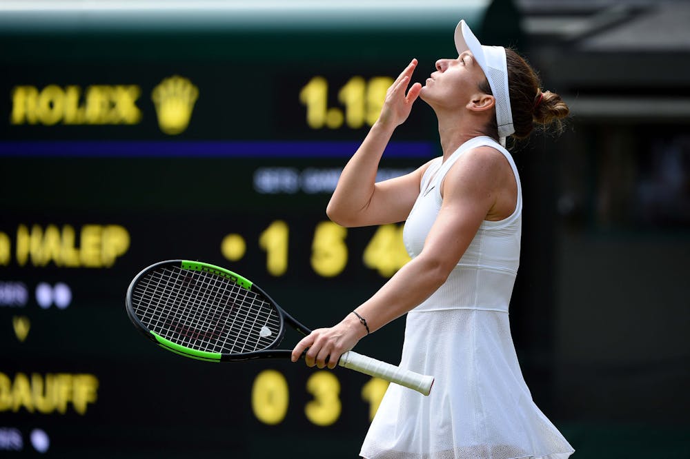 Simona Halep kissing the sky after her win agasinst Cori Gauff at Wimbledon 2019