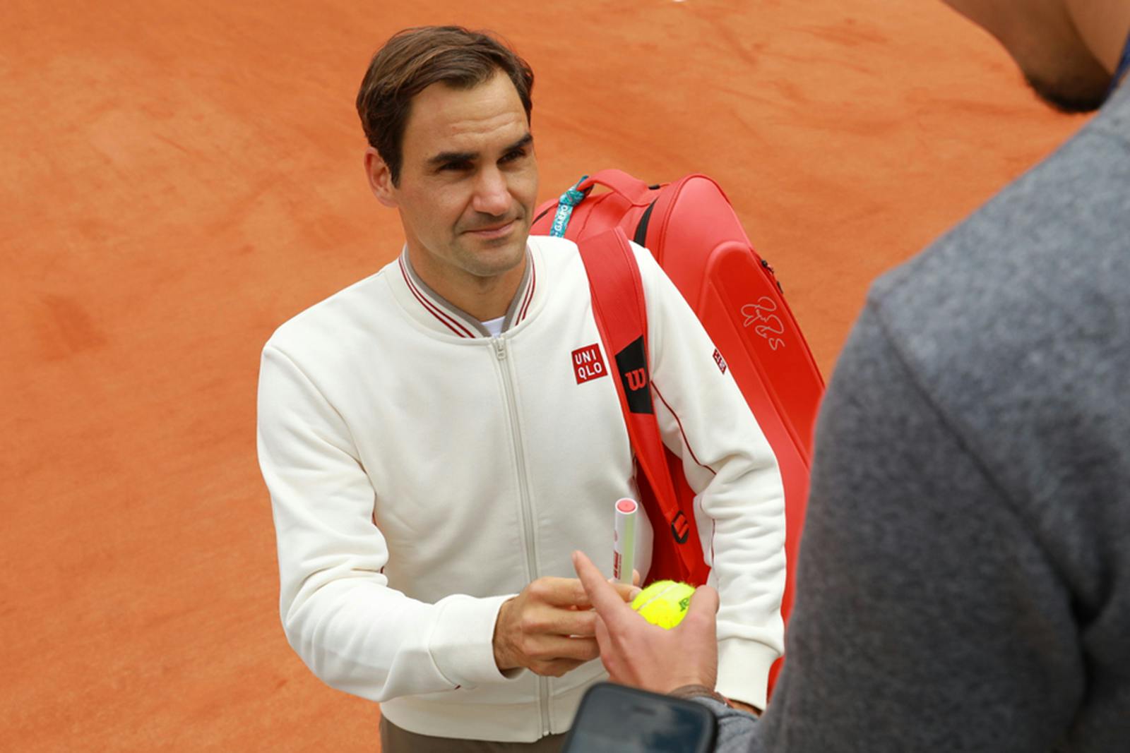 Roger Federer meets a fan at practice