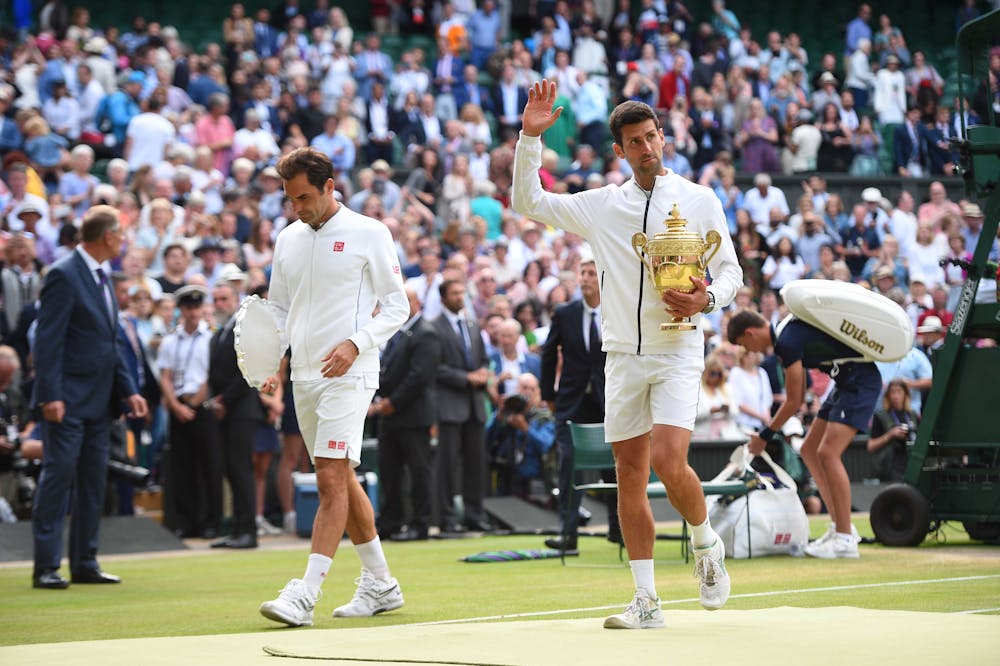 Novak Djokovic and Roger Federer walking with their trophies after the presentation at Wimbledon 2019
