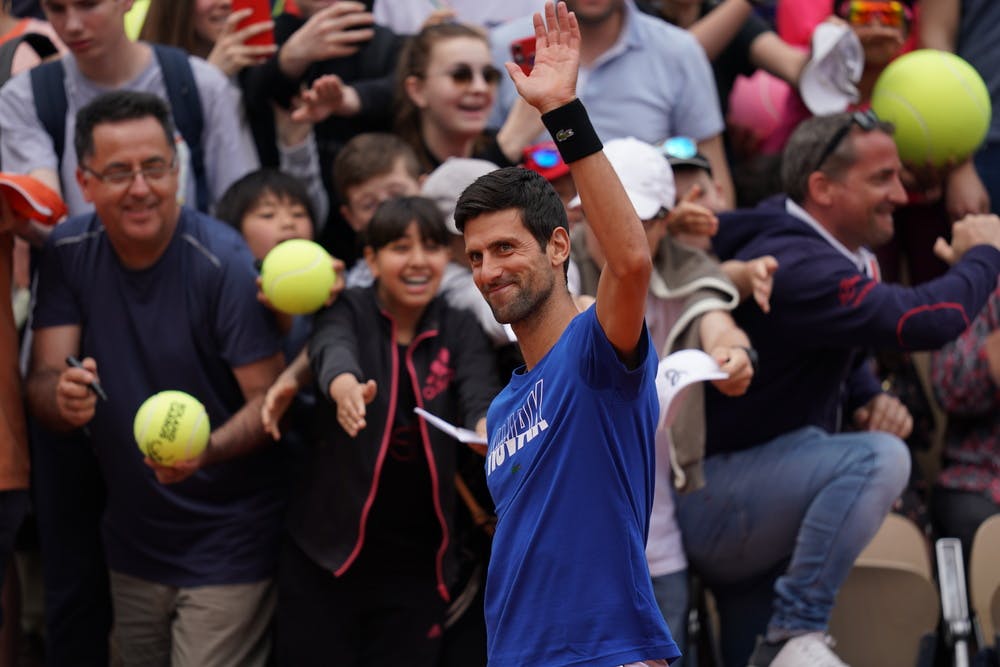 Novak Djokovic waves to fans on Kids Day.