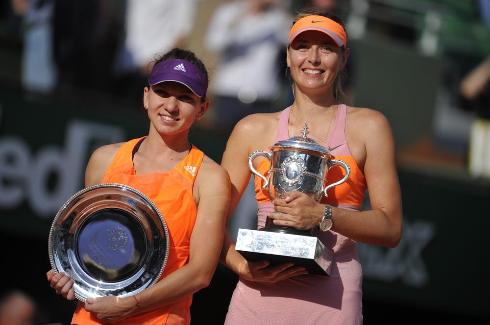 Maria Sharapova and Simona Halep posing with the 2014 Roland-Garros trophy