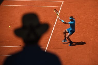 Rafael Nadal hitting a forehand at Roland-Garros 2018 in front of a shadow.